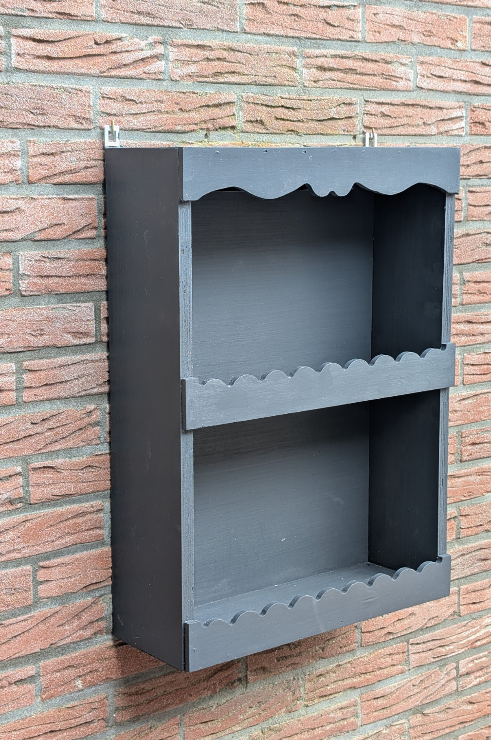 Detail van een netjes afgewerkt houten muurkastje