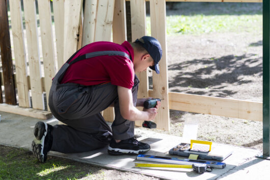 W.J. aan een werkbank in een kleine werkplaats met zicht op de tuin